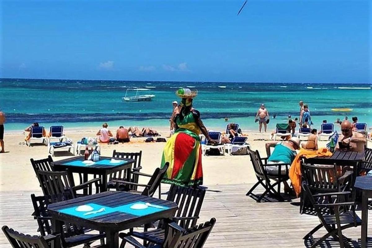 eine Frau in einem bunten Kleid steht am Strand