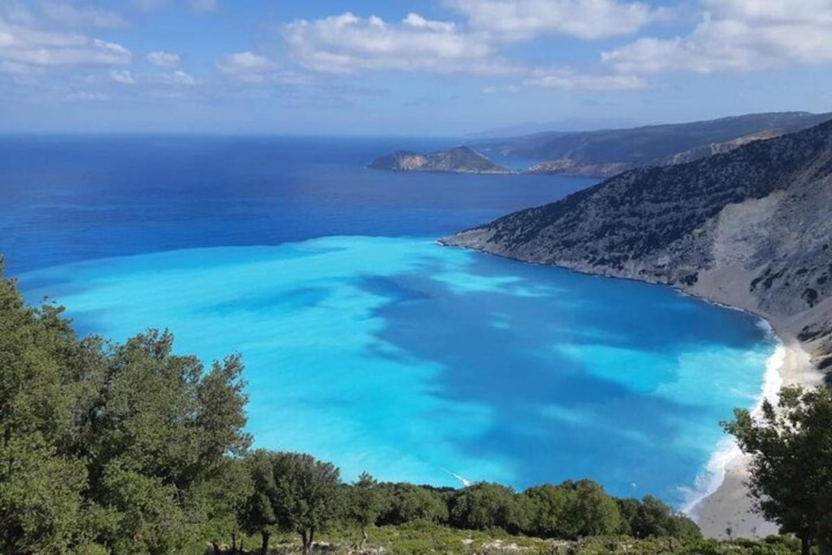 an aerial view of a beach with blue water