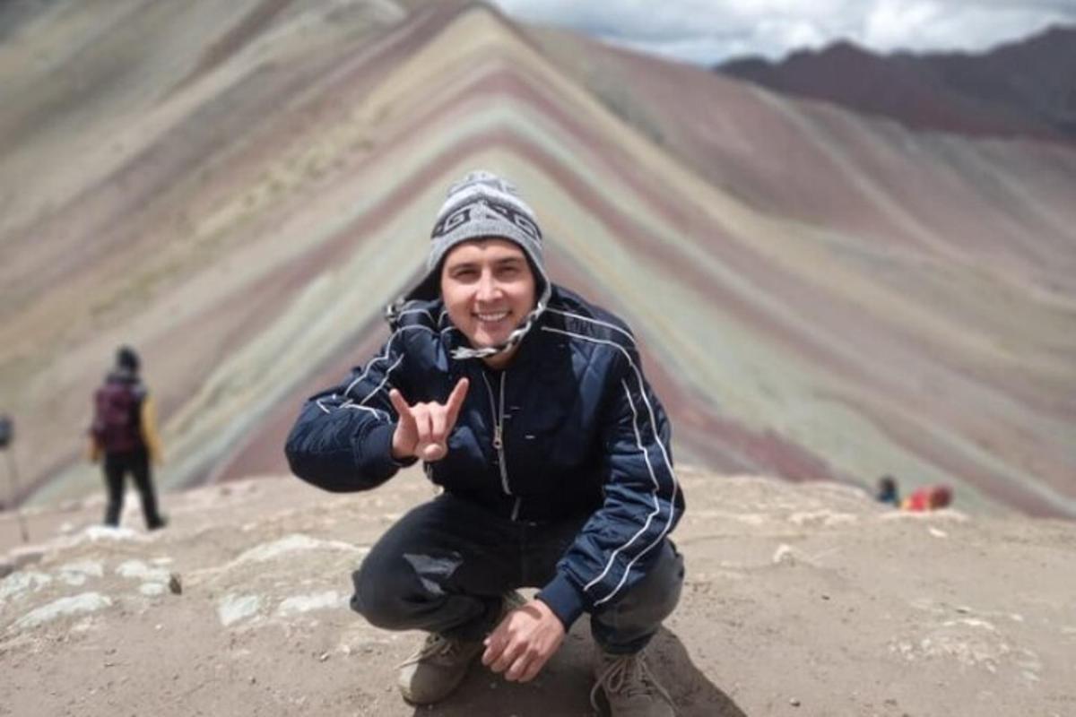un uomo inginocchiato sulla cima di una montagna