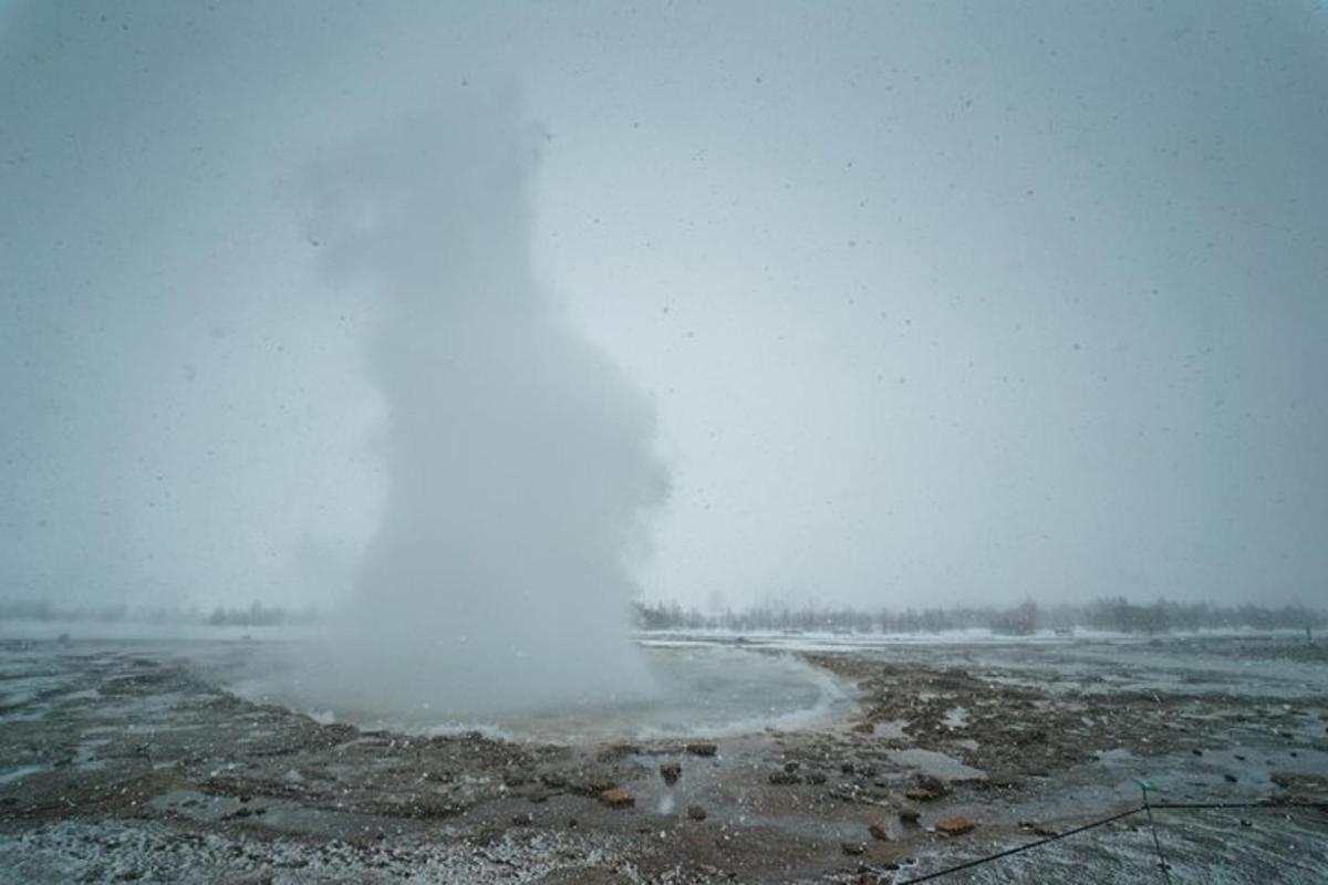 a geyser in the middle of a snow covered field