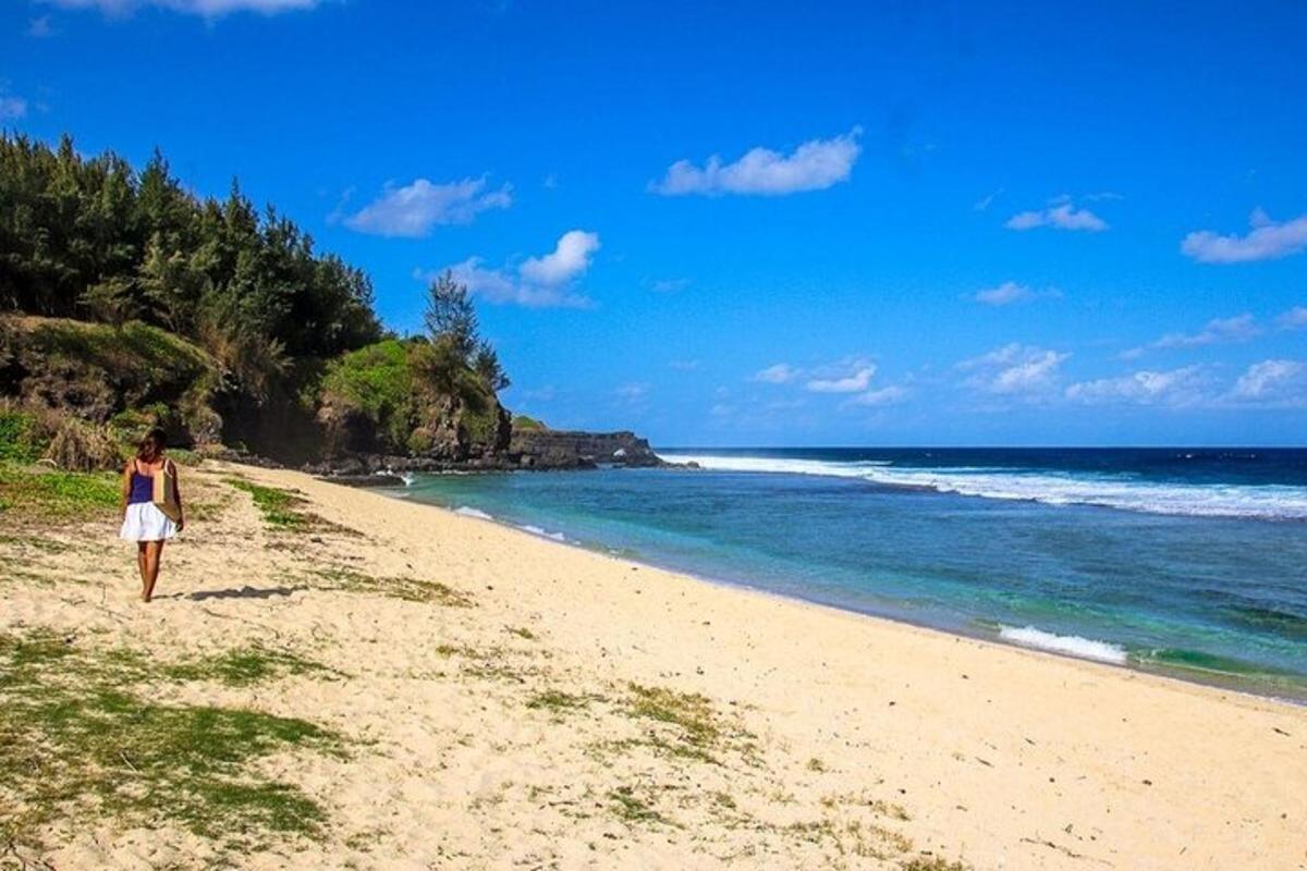 eine Frau, die an einem Strand in der Nähe des Ozeans spazieren geht