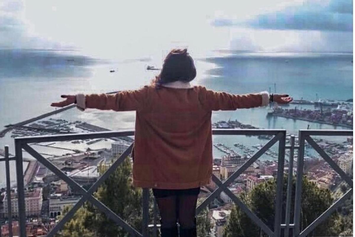 a woman standing on top of a tower with her arms outstretched