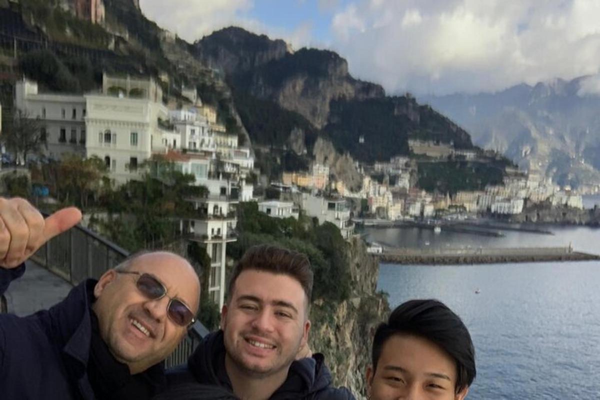 um grupo de três homens em pé no topo de uma montanha