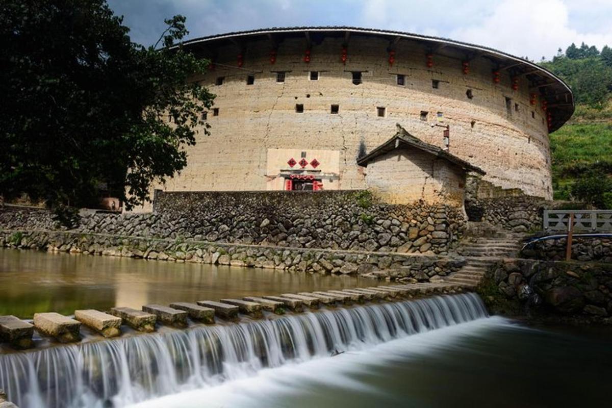 ein Gebäude mit einem Wasserfall vor einem Fluss