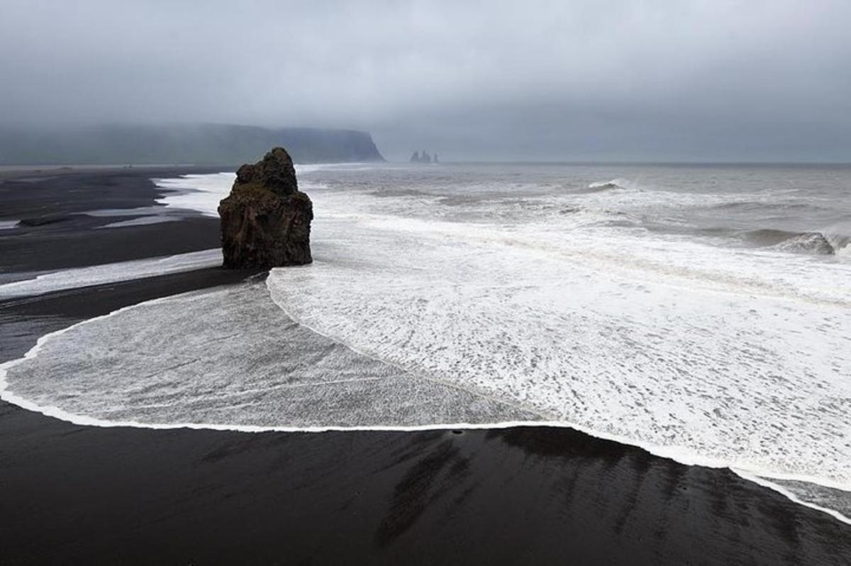 una roccia nell'acqua su una spiaggia