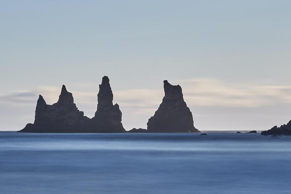 eine Gruppe von Felsen im Meer mit dem Himmel