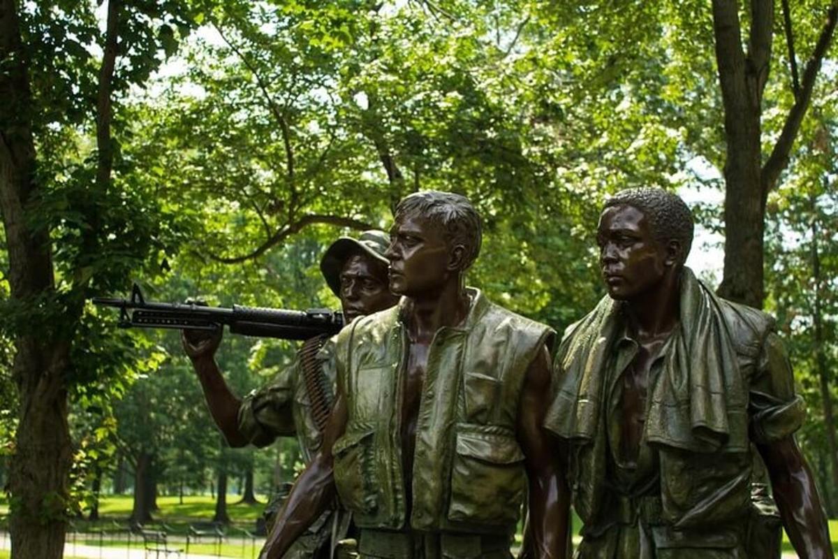 una statua di tre uomini con una pistola in un parco
