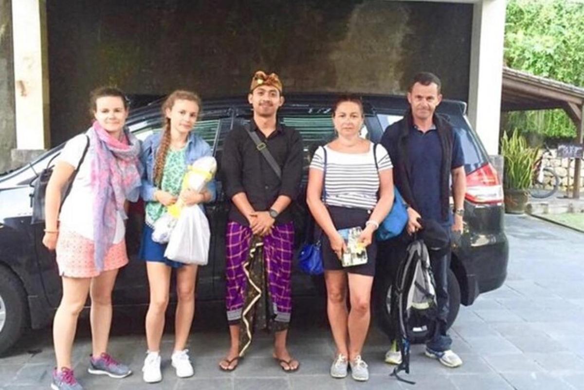 egy csoport ember áll egy autó előtt
