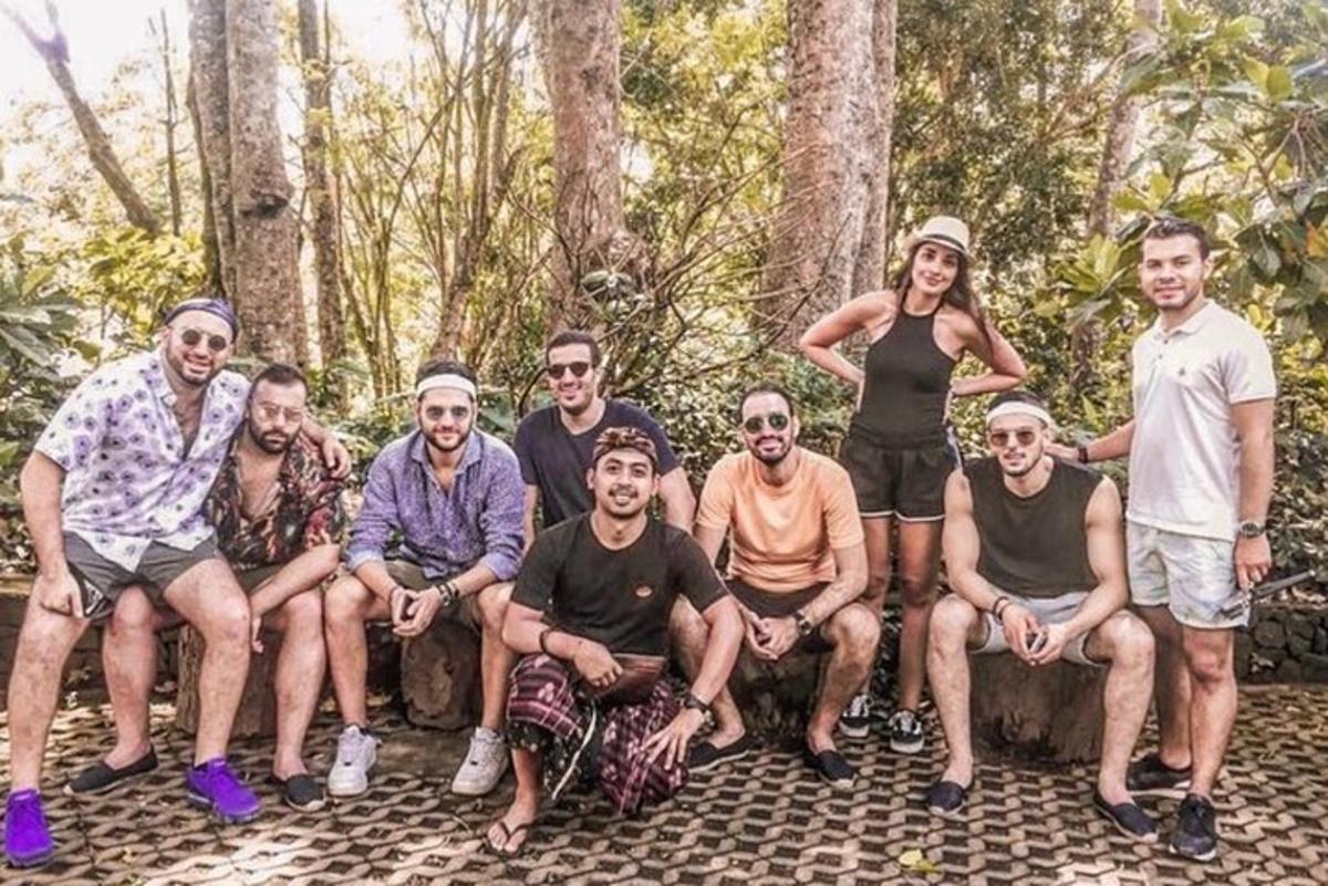 un grup de persones assegudes en un tronc al bosc