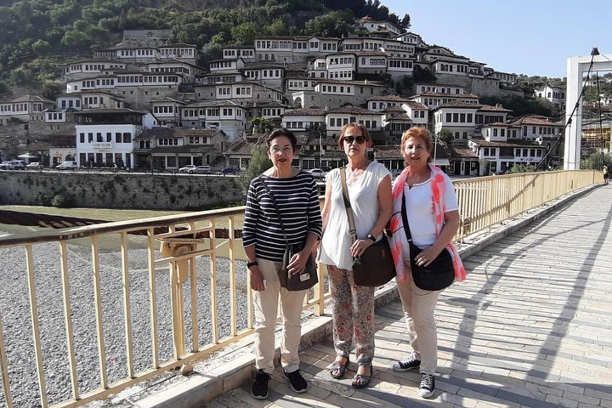 tre donne in piedi su un ponte di fronte a una città