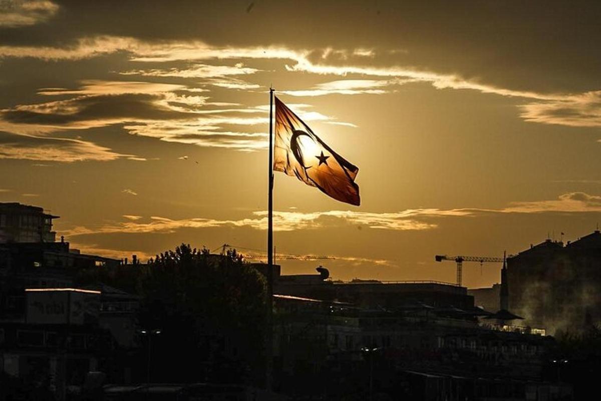 bendera di atas tiang dengan latar belakang matahari terbenam