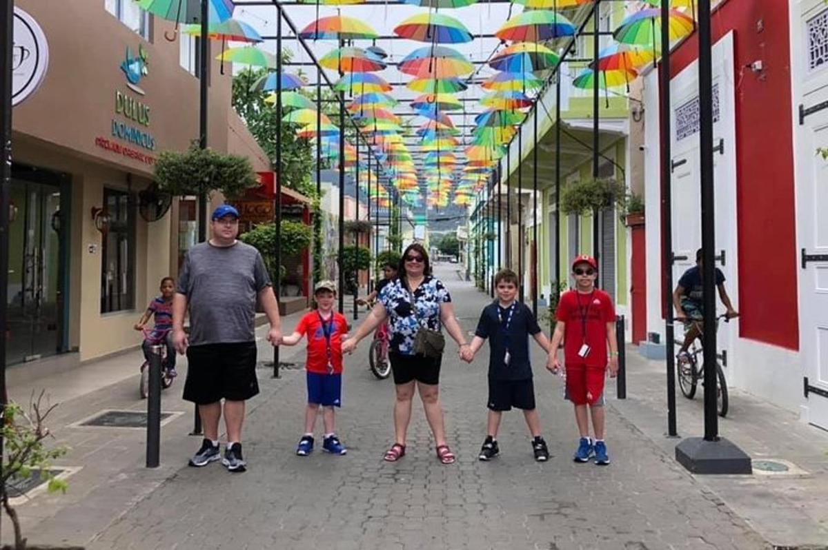 a family posing for a picture on a street with umbrellas