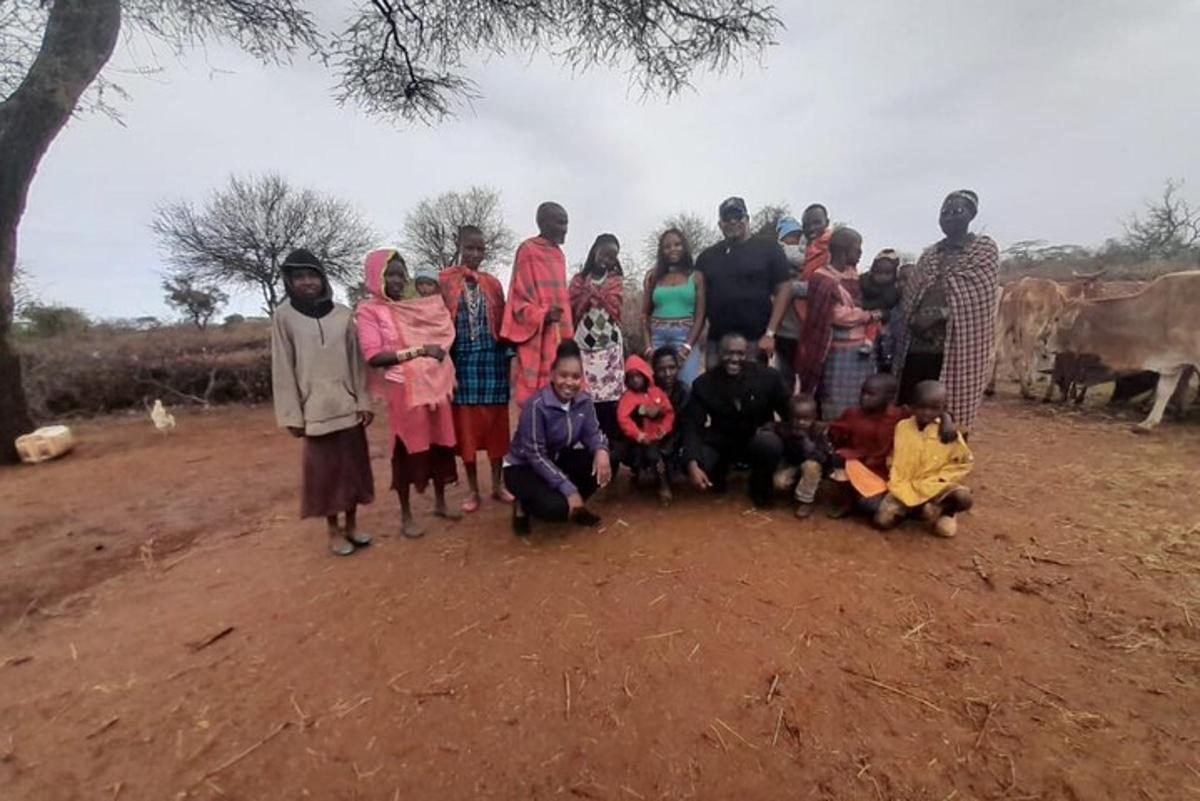 Un grupo de personas posando para una foto en un campo de tierra.