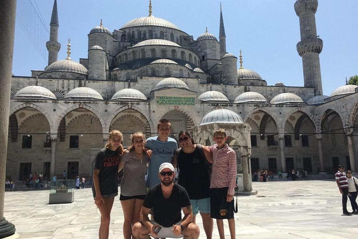 un gruppo di persone in posa davanti a una moschea