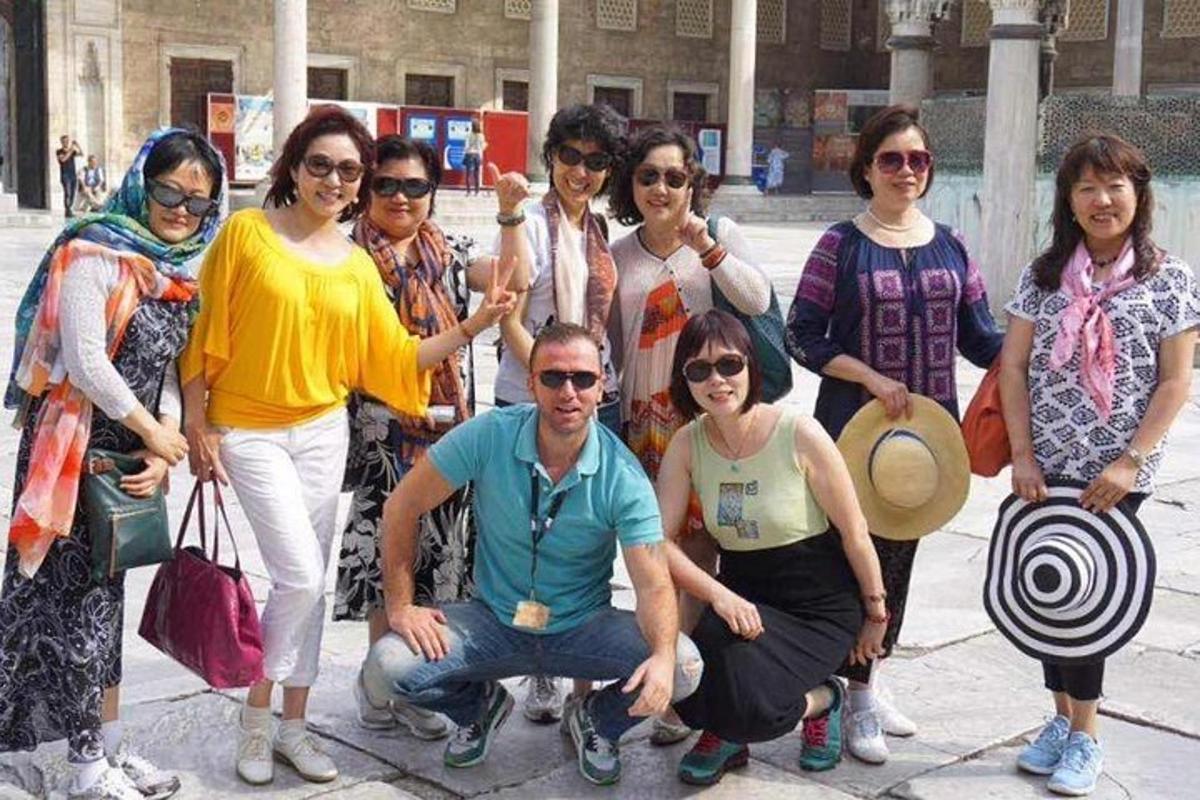 группа людей позируют для фотографии на тротуаре