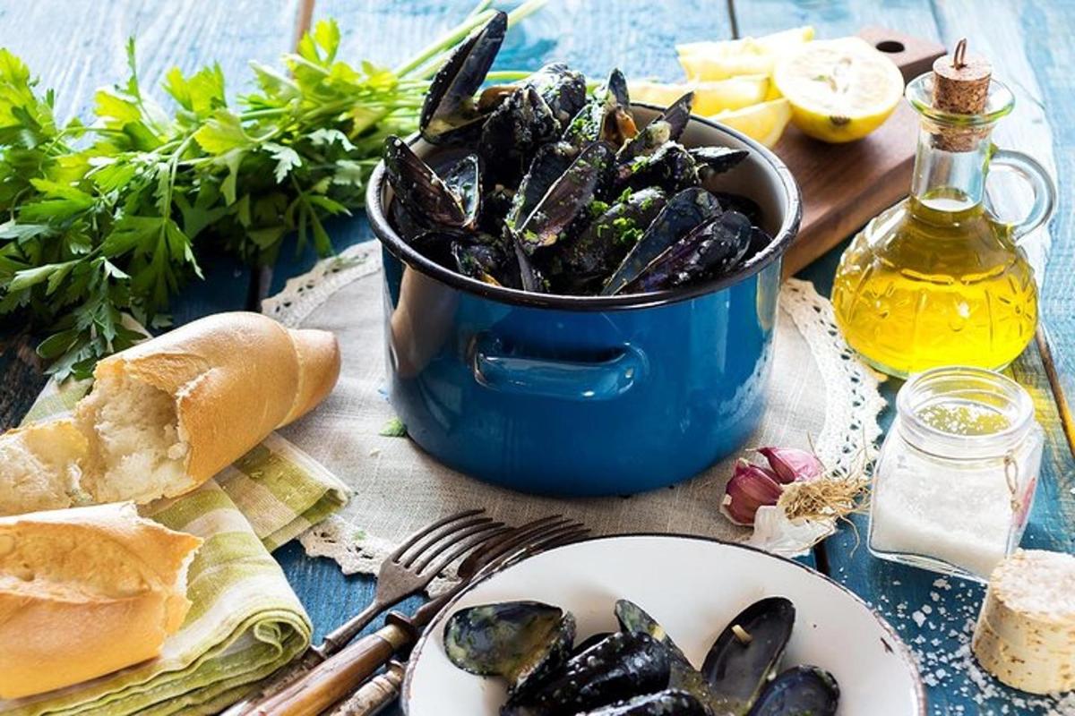 Una mesa con un cubo de mejillones y un plato de comida.