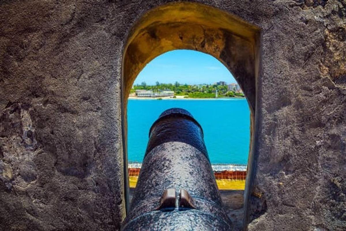 eine Person, die aus einem Fenster auf das Meer schaut