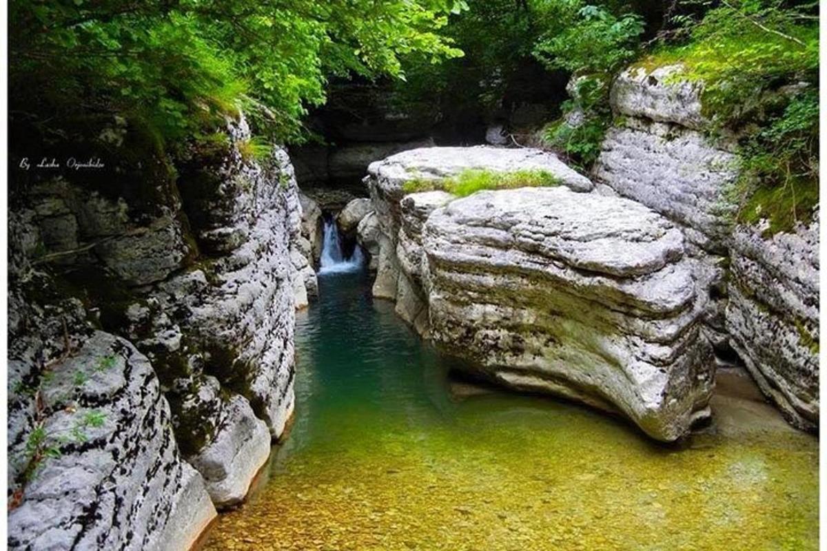 una piscina di acqua verde smeraldo tra due grandi rocce
