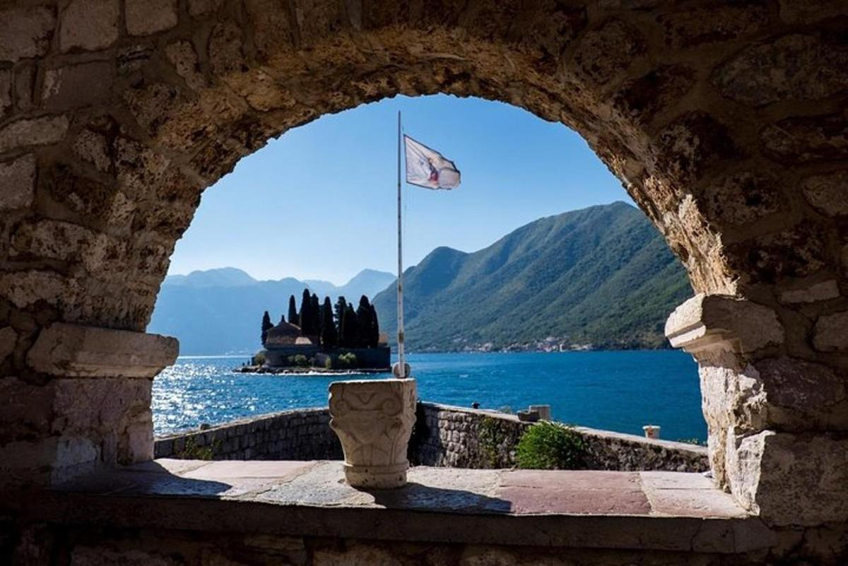 an archway with a view of the water and a flag