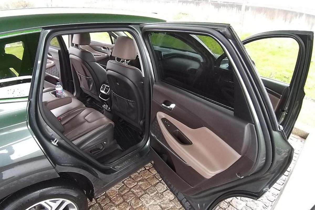 Un coche verde con la puerta abierta con los asientos.