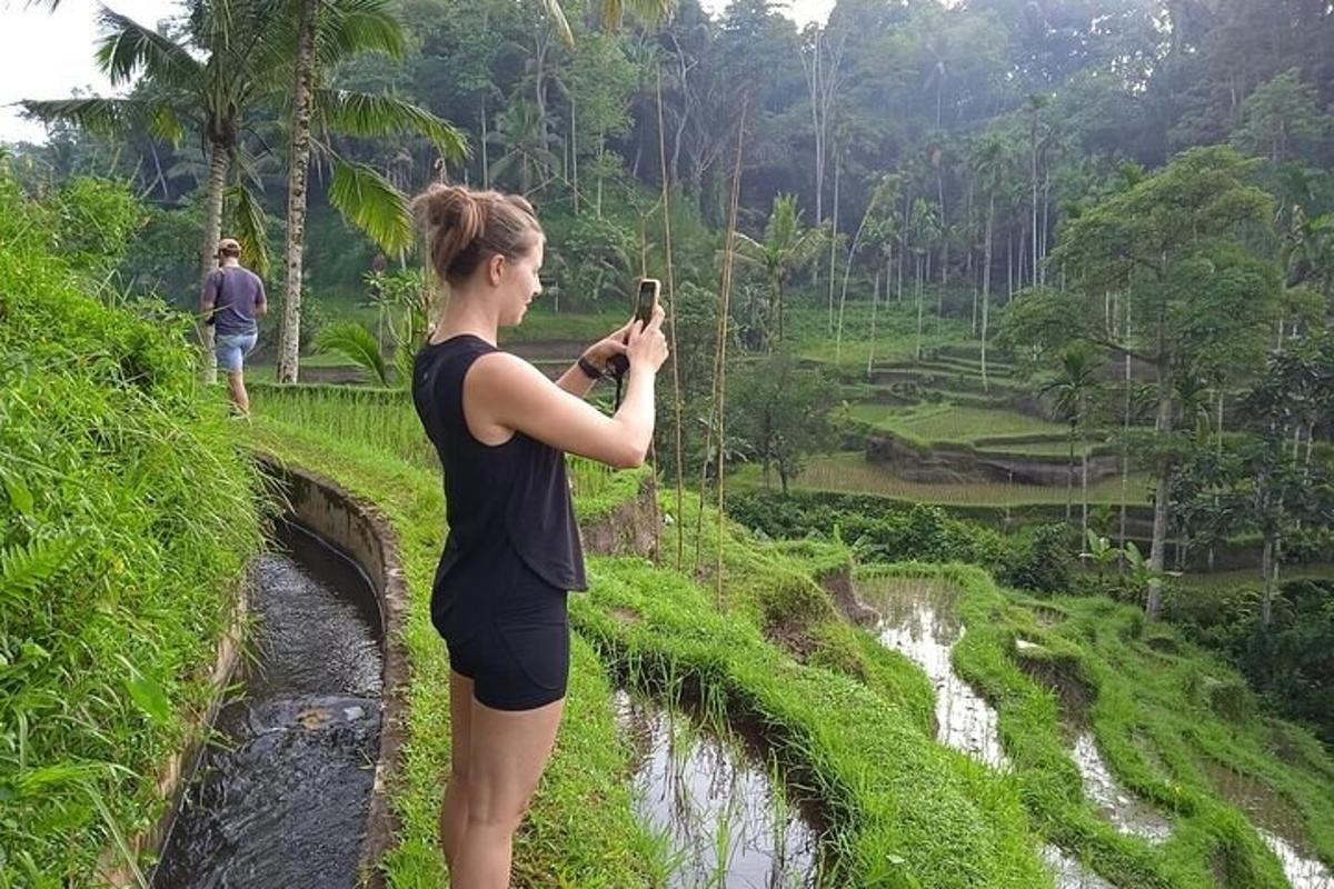 a woman taking a picture of a bridge with her camera