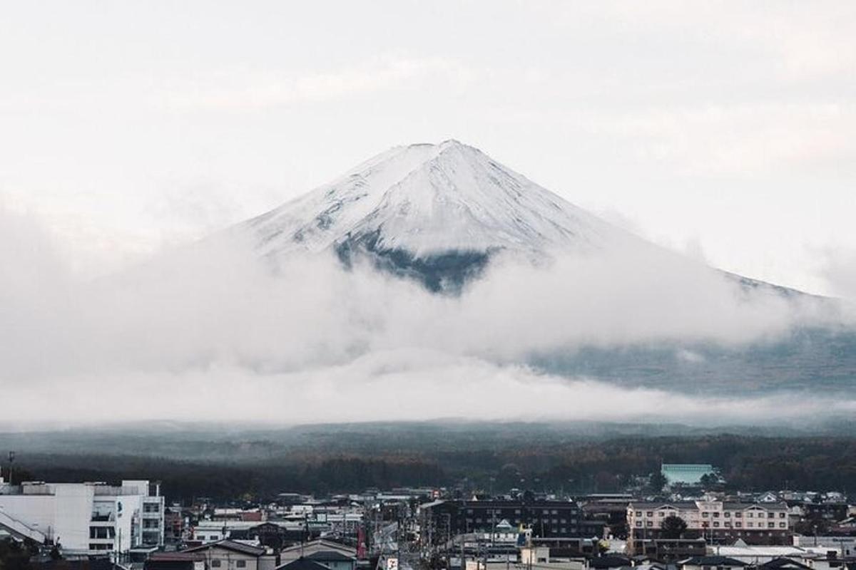 gunung yang tertutup salju di kota dengan awan