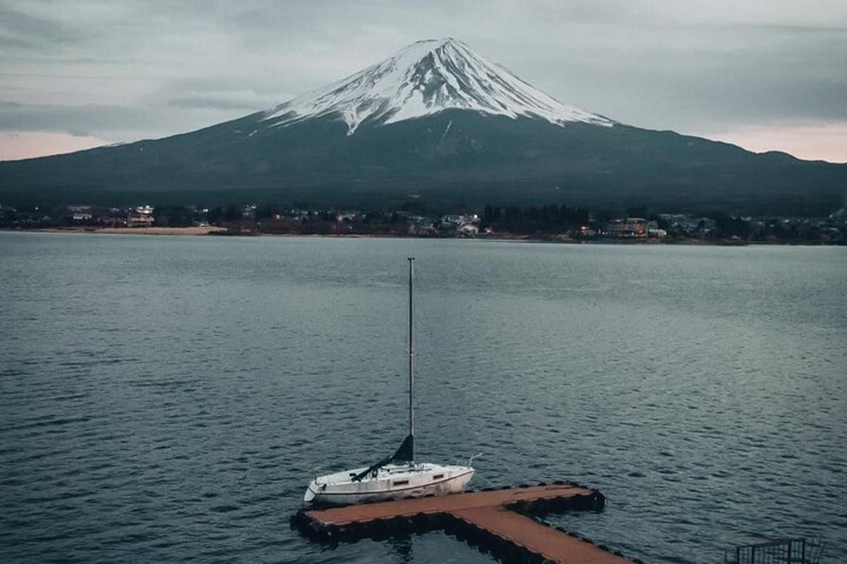 a boat in the water in front of a mountain