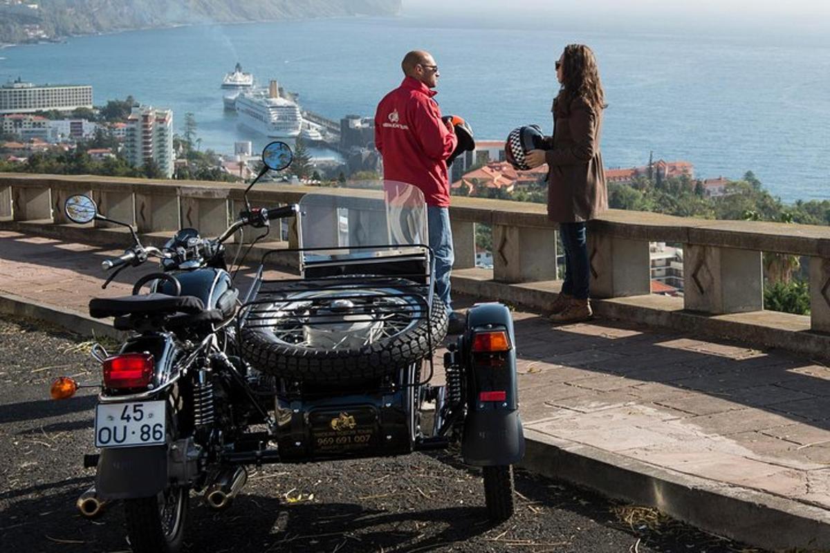 muž a žena stojící vedle motorky