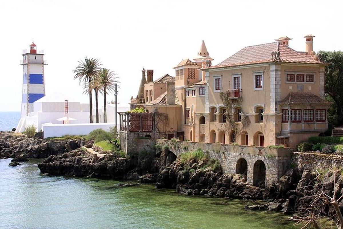 una casa en un acantilado junto al agua con un faro