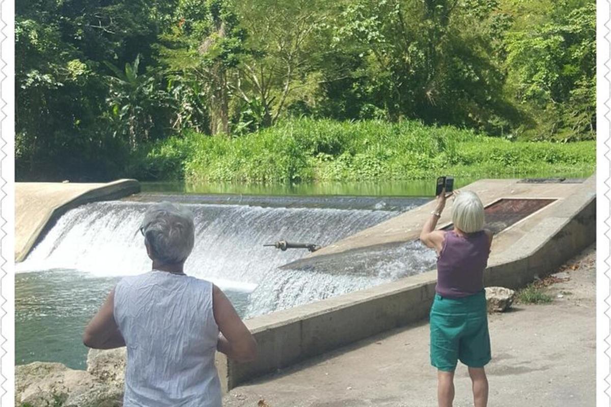 two people taking a picture of a waterfall