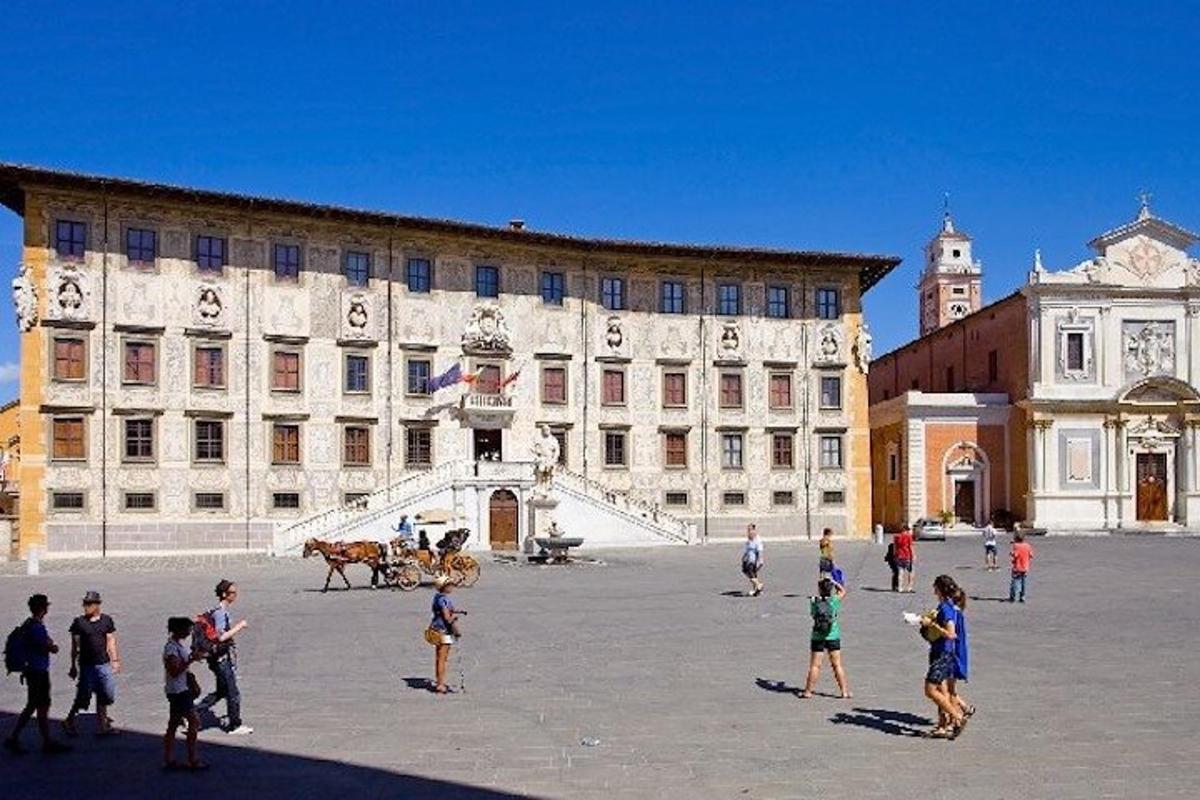 um grupo de pessoas em pé em frente a um grande edifício