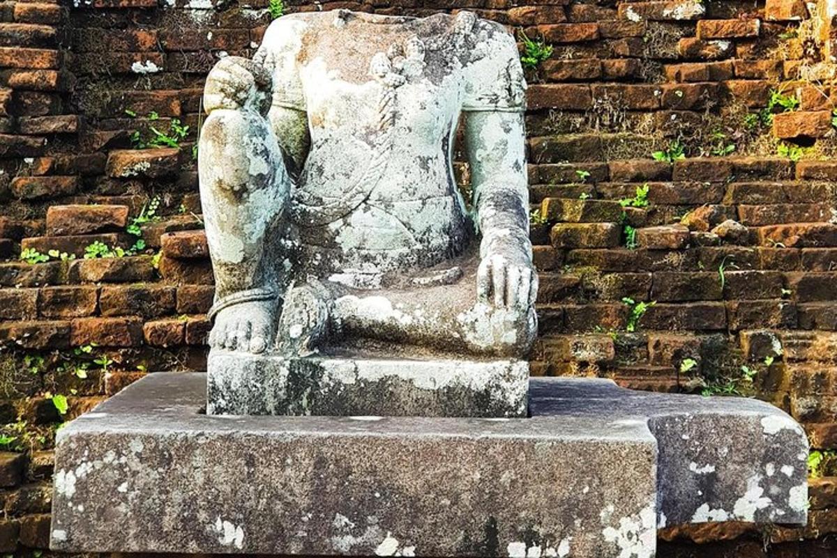 uma estátua em frente a uma parede de tijolos