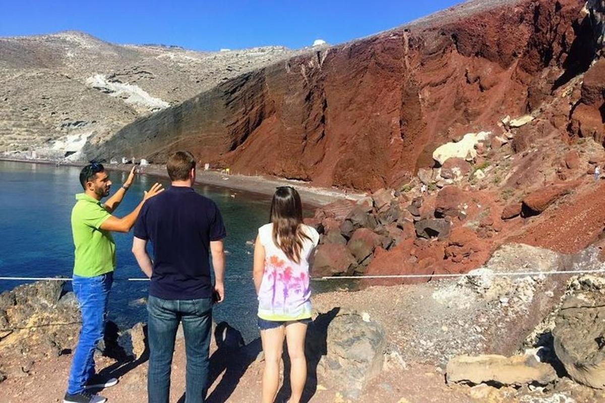 група з трьох людей стоїть на скелі біля води