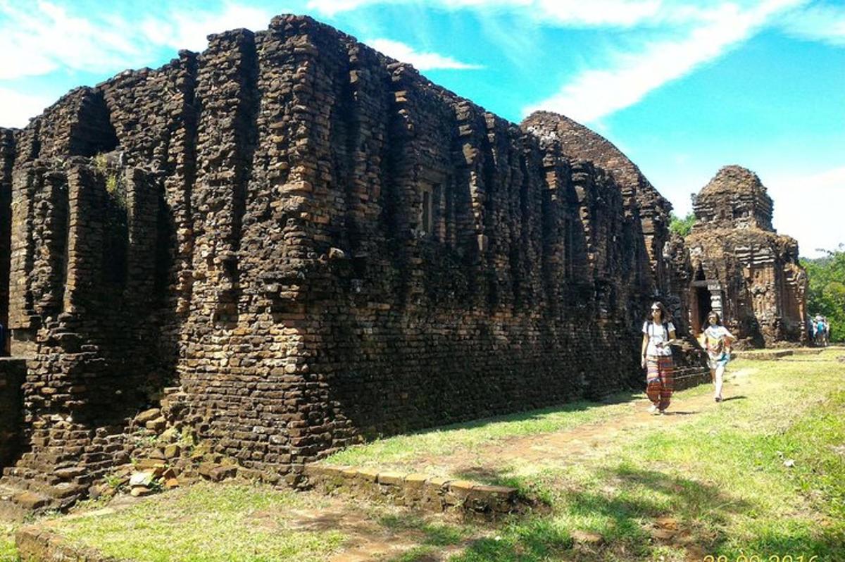 due persone che camminano davanti a un muro di pietra
