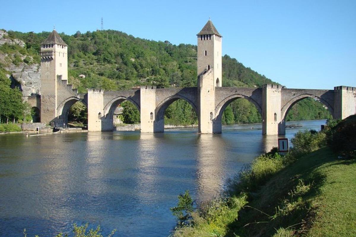 uma ponte sobre um rio com um castelo ao fundo