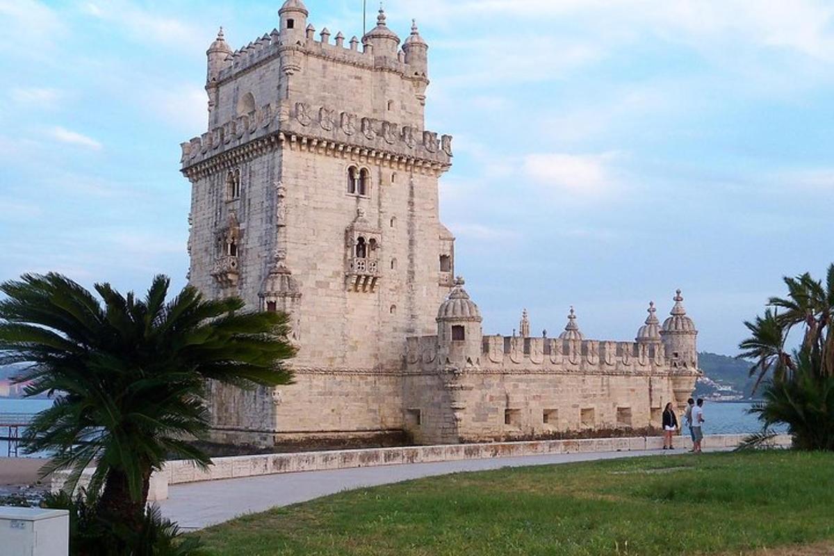 un grande edificio in pietra con una palma di fronte