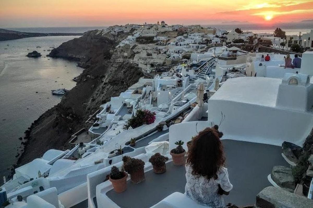 una donna seduta su una sporgenza che guarda una città