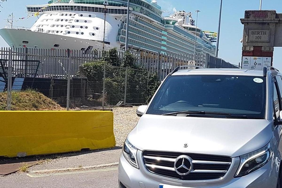 un'auto bianca parcheggiata davanti a una nave da crociera