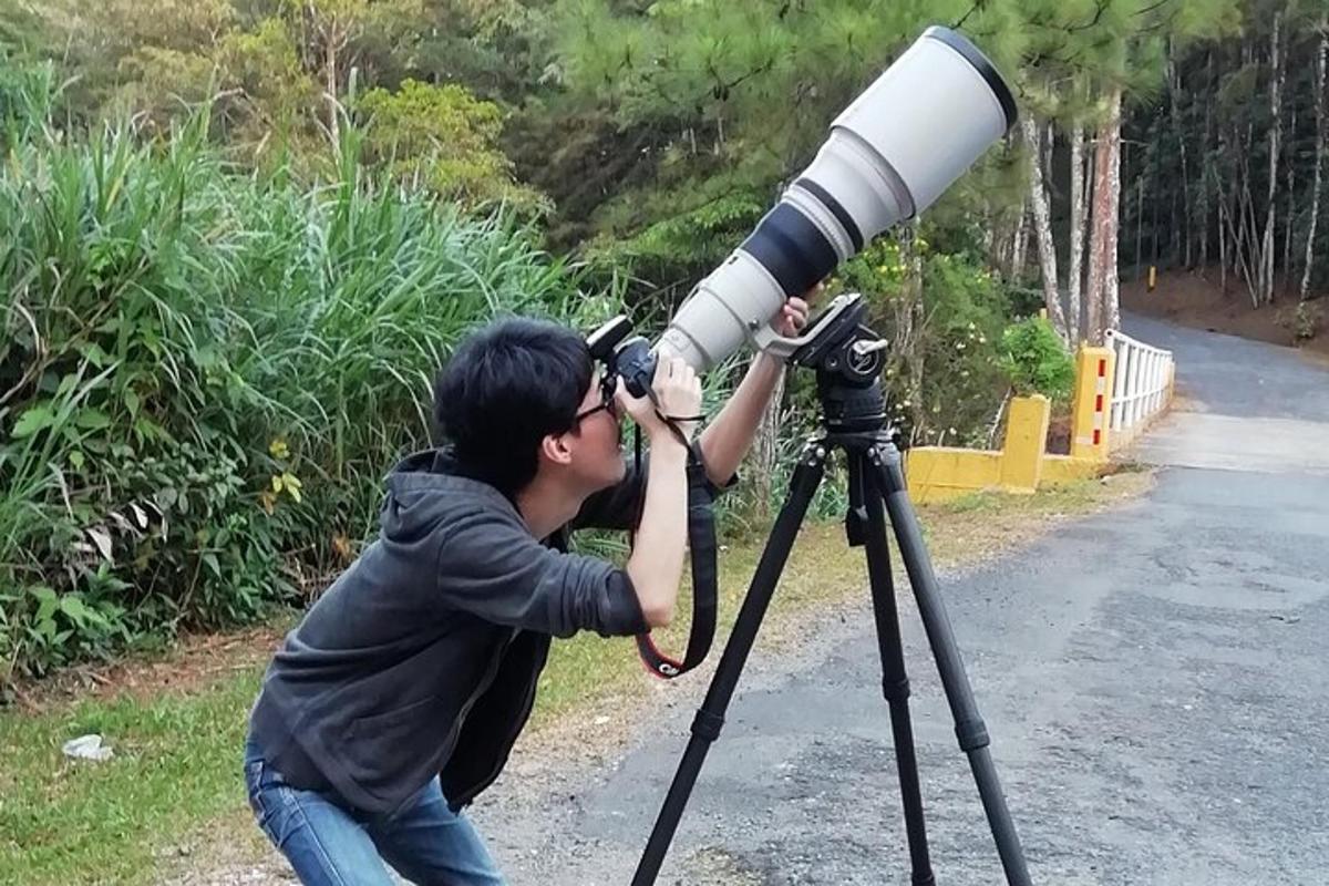 un uomo sta guardando attraverso un telescopio su un treppiede