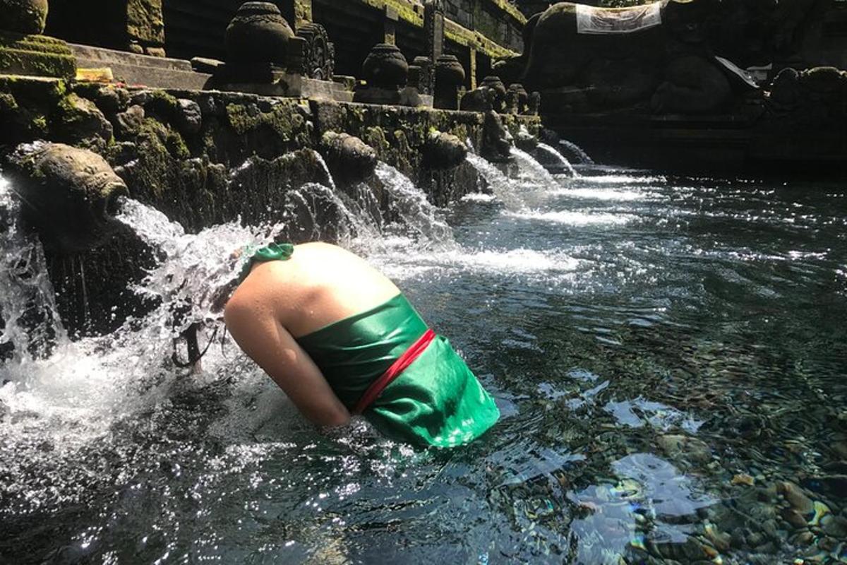 seseorang di dalam kolam air di air terjun