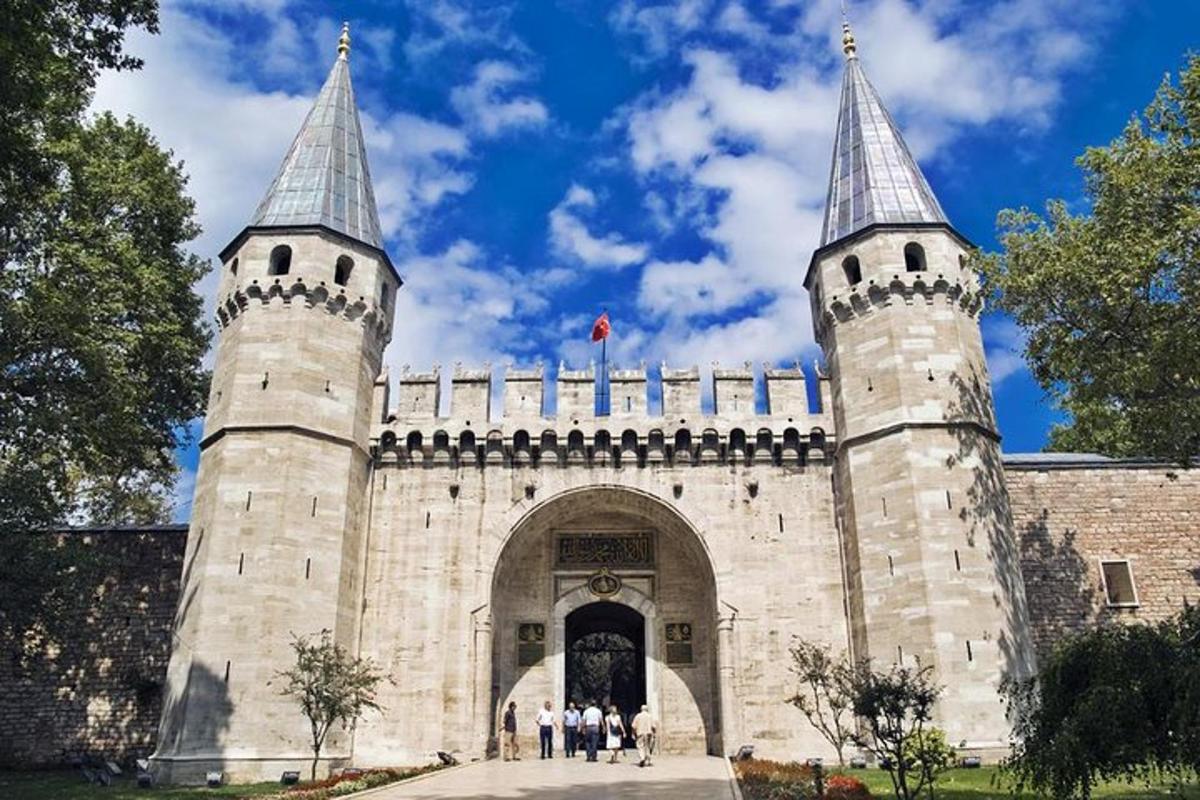 a castle with two towers with people walking through it