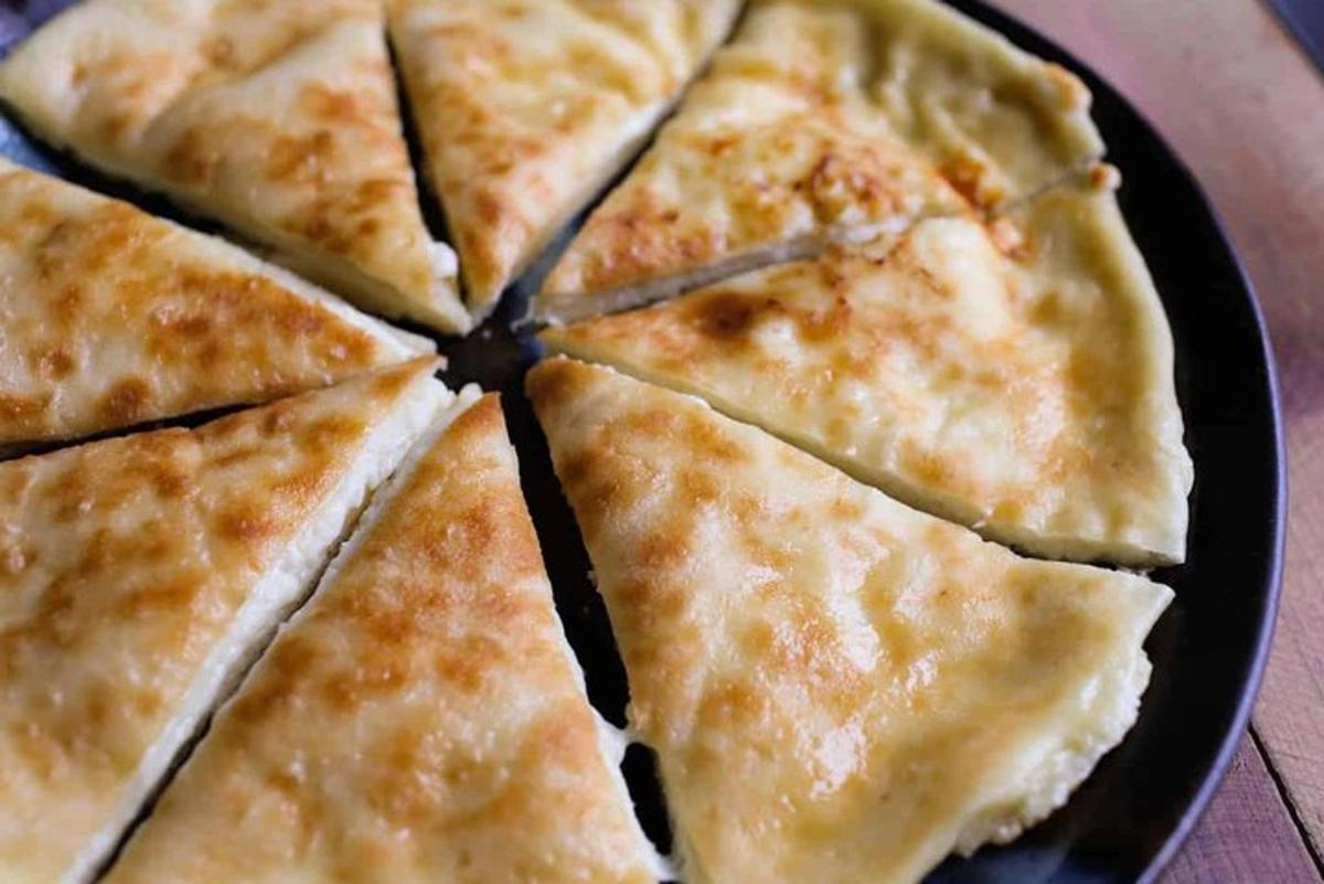 gambar dekat pizza yang dipotong menjadi kepingan