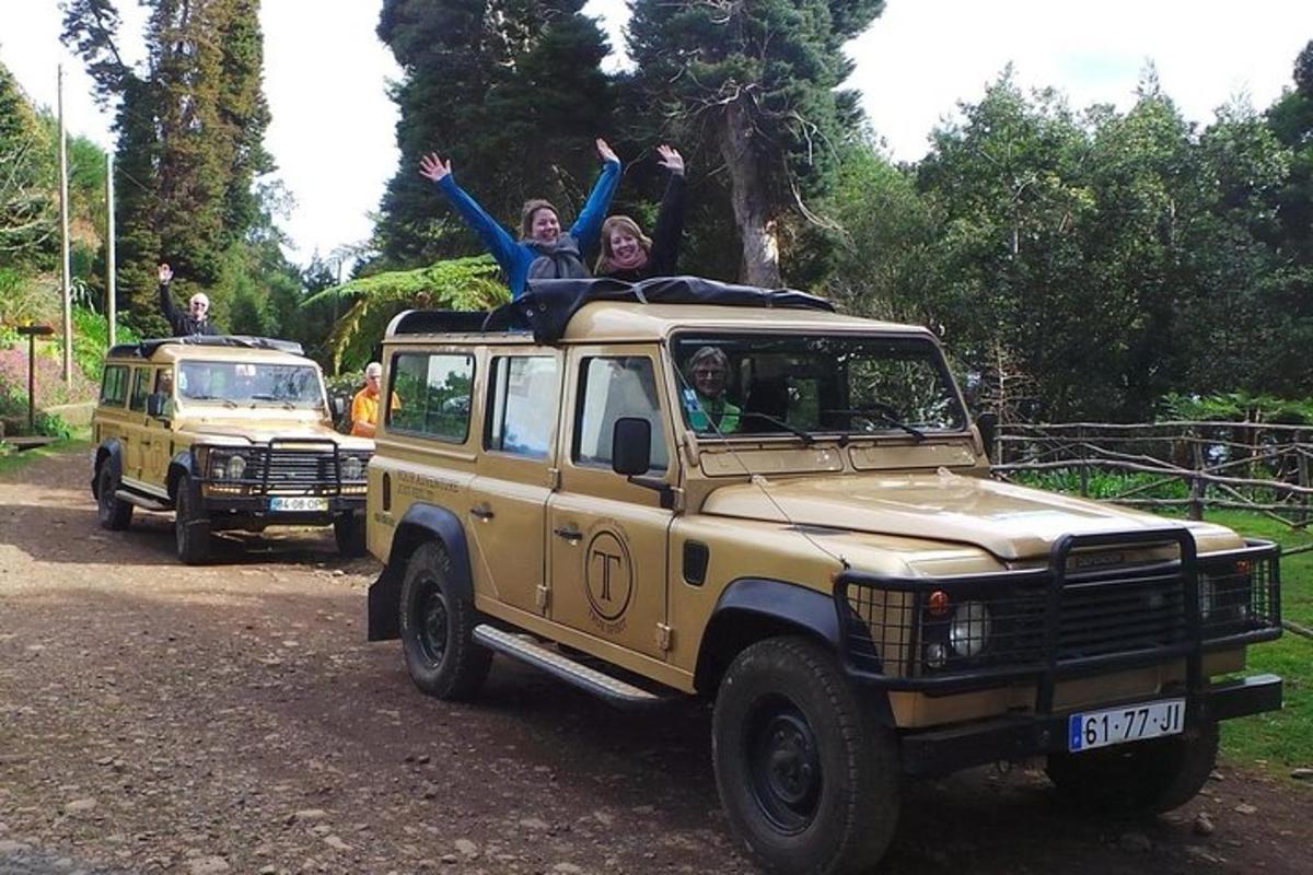 Două persoane stau pe un jeep galben