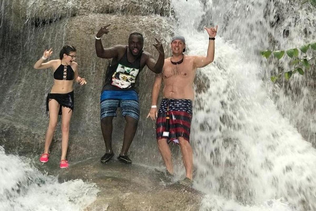 Þrír menn standa fyrir framan foss