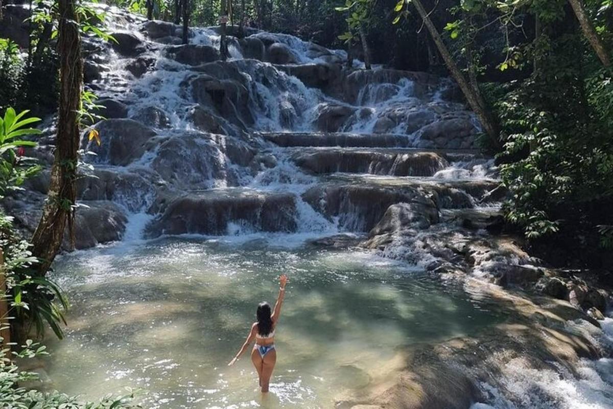 een vrouw in een plas water voor een waterval
