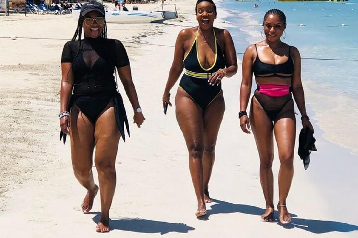 duas mulheres de biquíni caminhando na praia