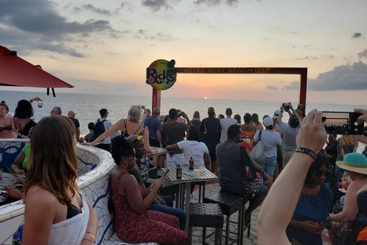 uma multidão de pessoas sentadas em um bar na praia