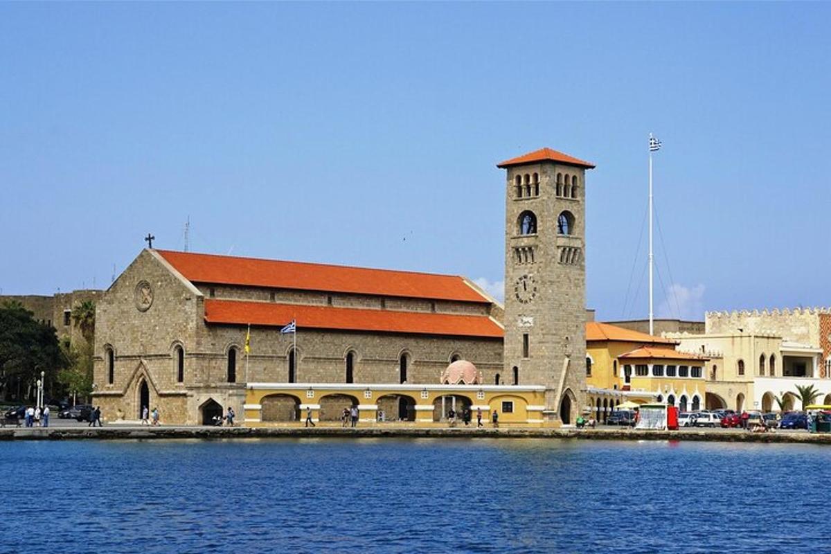 a large building with a clock tower next to a body of water