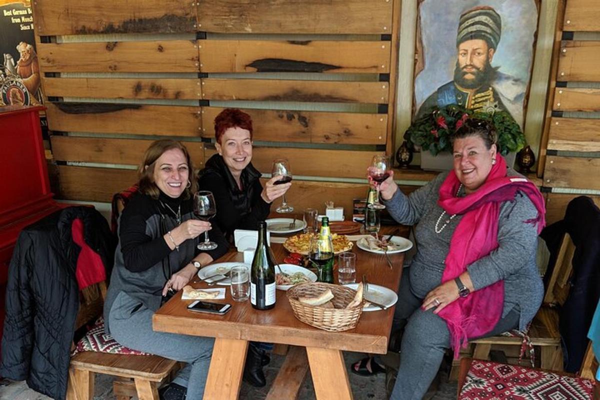 um grupo de pessoas sentadas à mesa com taças de vinho
