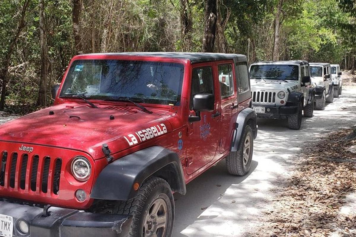 una jeep rossa parcheggiata su una strada sterrata